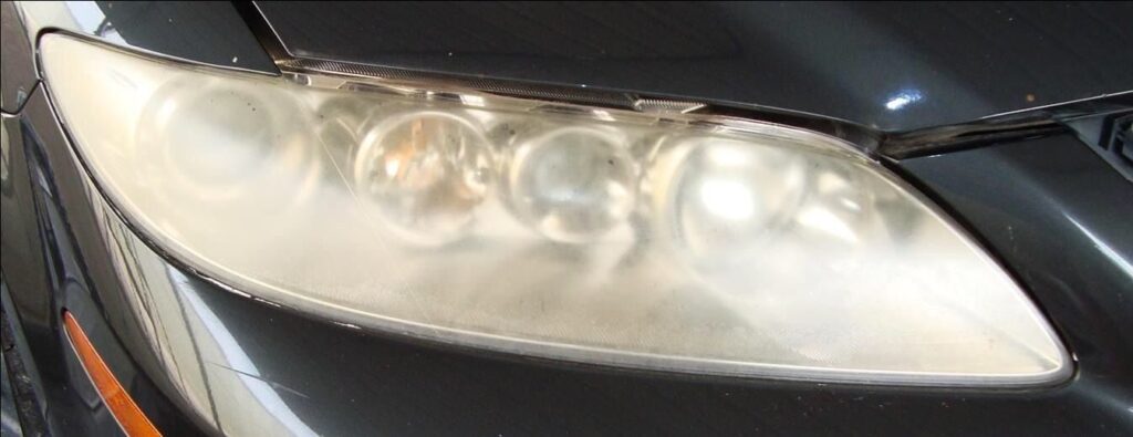 Faro empañado en primer plano de un auto oscuro