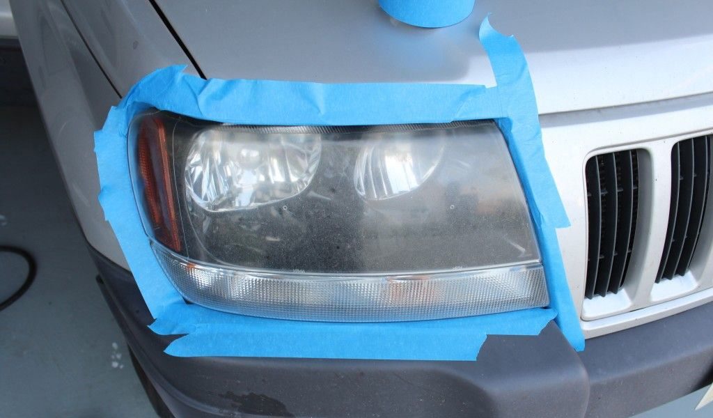 Faro opaco con cinta de protección antes del pulido en una camioneta