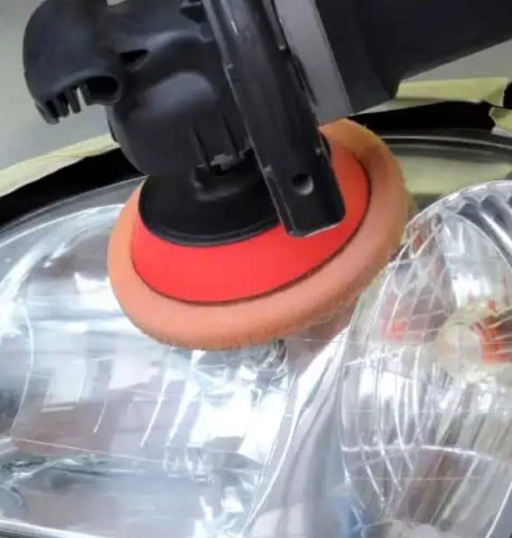 Pulidora orbital con esponja naranja trabajando sobre un faro: pulido de faros